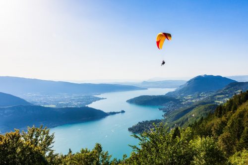 France Alpes parapente lac montagnes Le tour des Aravis s'achève au bord du magnifique lac d'Annecy, survolé par de nombreux parapentes